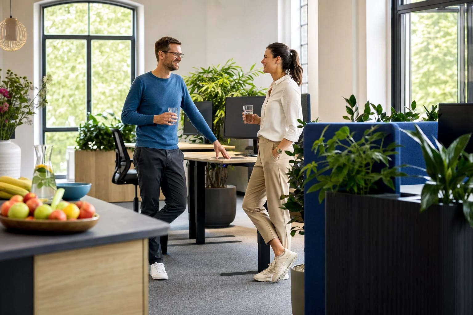 KI-generiertes Bild: Mitarbeitende machen eine gesunde Pause in einem hellen, begrünten Büro mit Obst und Steharbeitsplätzen.