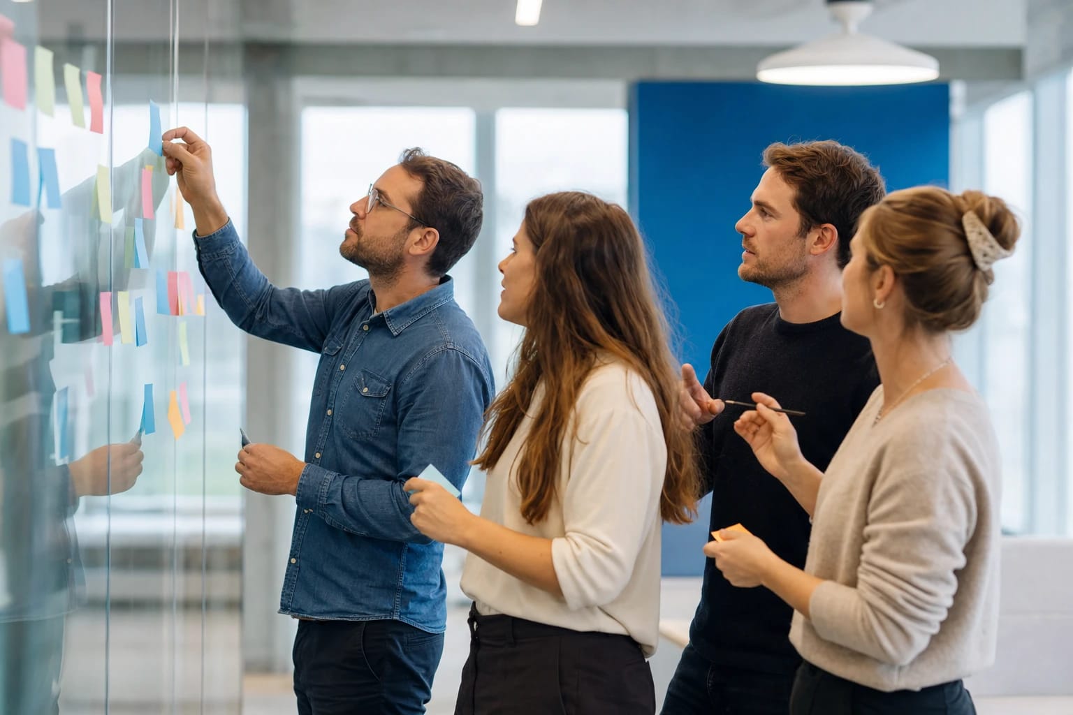 KI-generiertes Bild: Team erarbeitet gemeinsam eine Aufgabe an einer mit Haftnotizen bestückten Wand – aktiver Teamentwicklungs-Workshop.