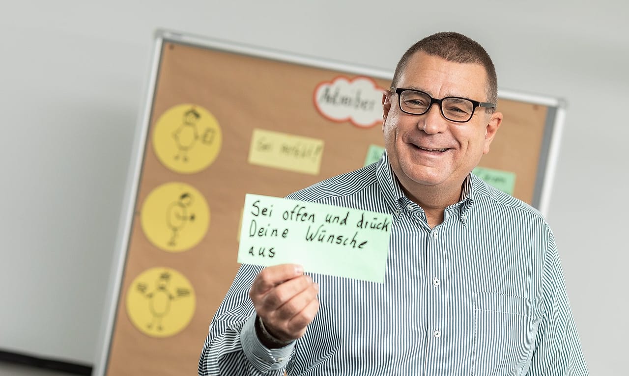 Alexander Preidt mit Moderationskarte vor einer Pinnwand